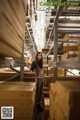 A woman standing in a large warehouse filled with boxes.