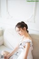 A woman sitting on a couch reading a book.