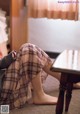 A woman sitting on the floor next to a table.