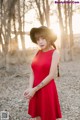 A woman in a red dress and a black hat.