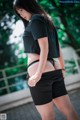 A woman in a black shirt and black shorts posing for a picture.