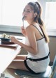 A woman sitting at a table eating a bowl of ice cream.