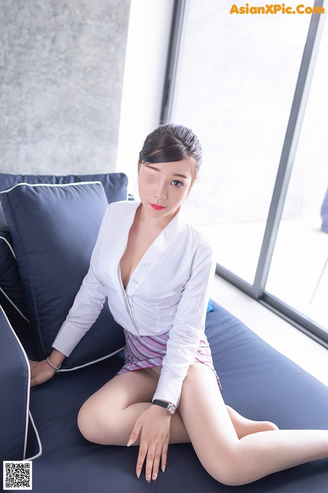 A woman sitting on top of a blue couch.