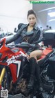 A woman sitting on top of a red motorcycle.